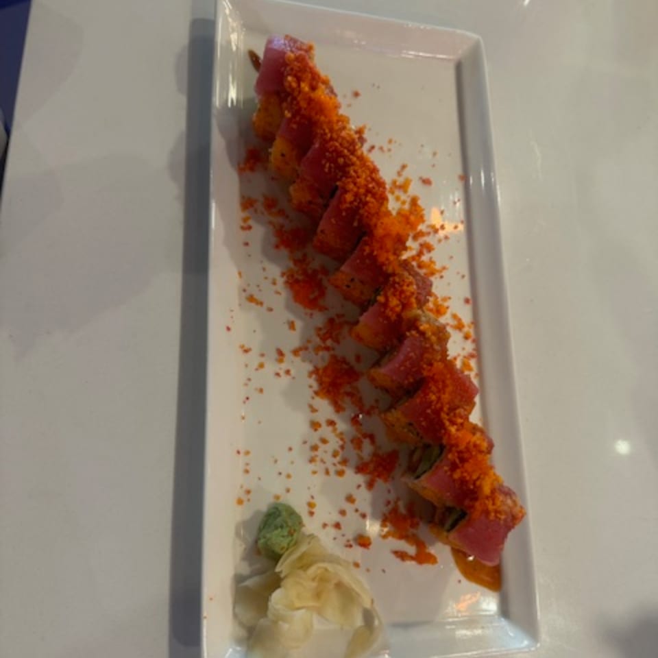 Sushi Yama's tuna roll, topped with bright orange roe, served with wasabi and pickled ginger.